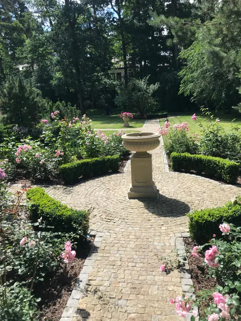 Fontanna, kwitnące rabaty i formowane krzewy